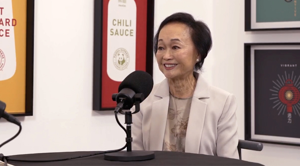 Peggy sitting at table recording podcast